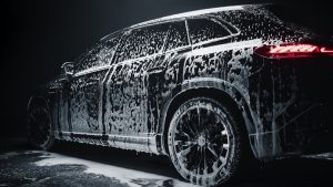 Car in car wash soaking with soap